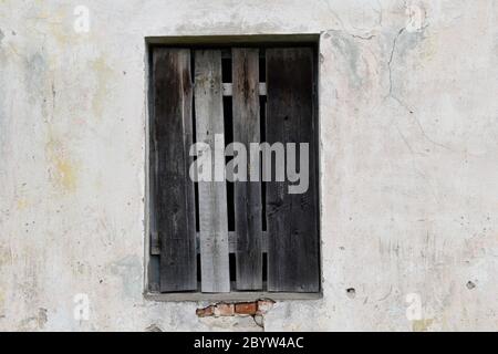 Fenster mit vertäfeltem Gebäude mit verbrannten, verfärbten Brettern. Stockfoto