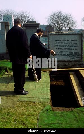 Glasgow Schottland Griechisch-orthodoxe Beerdigung in der Kathedrale von St Luke Friedhof Priester gießt Olivenöl in das Grab Stockfoto