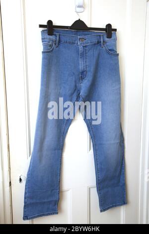 Ein Paar blaue Jeans hängt an der Tür Stockfoto
