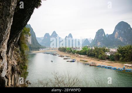 Der Blick auf den Li Fluss und Karstberge / Hügel und Kreuzfahrtschiffe in Yangshuo, Guangxi, China, einem der beliebtesten Reiseziele Chinas. Stockfoto