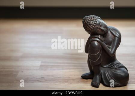 Buddhah Skulptur auf Schreibtisch - Miniatur Buddhah Statue auf Schreibtisch - Konzept Bild für Vermittlung, Achtsamkeit, Entspannung, Philosophie Stockfoto