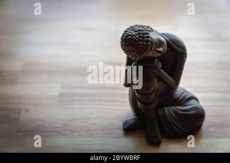 Buddhah Skulptur auf Schreibtisch - Miniatur Buddhah Statue auf Schreibtisch - Konzept Bild für Vermittlung, Achtsamkeit, Entspannung, Philosophie Stockfoto
