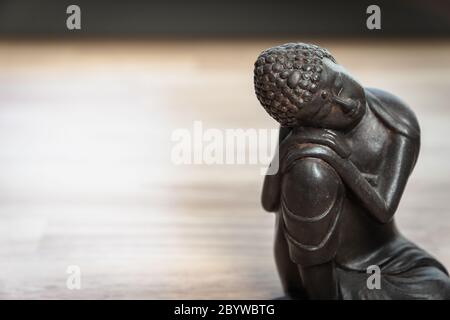 Buddhah Skulptur auf Schreibtisch - Miniatur Buddhah Statue auf Schreibtisch - Konzept Bild für Vermittlung, Achtsamkeit, Entspannung, Philosophie Stockfoto
