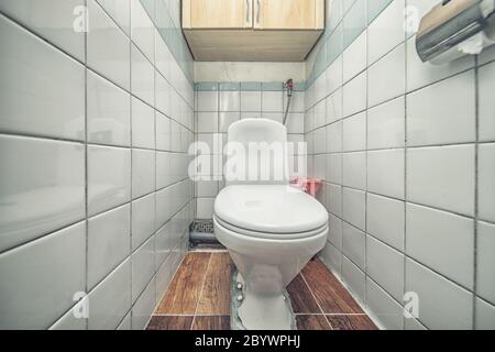 Weiß eingebaute WC-Schüssel in modernem Bad mit Papierhalter und WC-Bürste Stockfoto