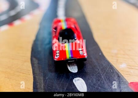 Generische Spielzeugautos im Vordergrund auf einer Straße. Stockfoto