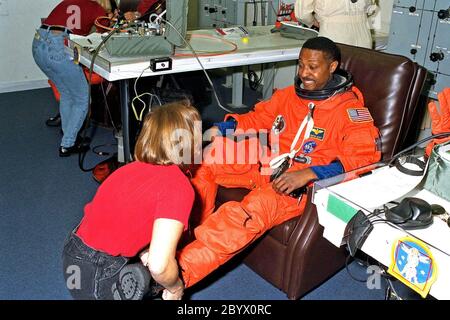 STS-87 Mission Specialist Winston Scott dockt seinen Start und Entry Suit mit der Unterstützung eines Suit-Technikers im Operations and Checkout Building. Dies ist Scotts zweiter Weltraumflug. Er und die fünf anderen Crew-Mitglieder werden in Kürze zum Launch Pad 39B aufbrechen, wo das Space Shuttle Columbia auf eine 16-tägige Mission zur Durchführung von Schwerelosigkeit und Sonnenforschung wartet. Scott soll während der STS-87 einen extravehicular activity Spacewalk mit Mission Specialist Takao Doi, Ph.D., der National Space Development Agency of Japan, durchführen. Er führte auch einen Spacewalk auf STS-72 Stockfoto