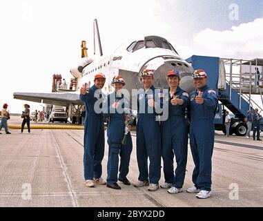 DIE STS-84 Crew-Mitglieder geben Pressevertretern und anderen Zuschauern auf der KSC-Runway 33 nach der Landung der erfolgreichen neuntägigen Mission einen Daumen nach oben. Von links sind Mission Specialist Jean-Francois Clervoy von der Europäischen Weltraumorganisation, Pilot Eileen Marie Collins, Commander Charles J. Precourt, Mission Specialist Elene V. Kondakova von der Russischen Weltraumorganisation und Mission Specialist Carlos I. Noriega. Nicht gezeigt werden Mission Specialist Edward Tsang Lu und der zurückkehrende Astronaut und mir 23 Crew Mitglied Jerry M. Linenger. STS-84 war die sechste Andockung des Space Shuttles an den russischen Space Stati Stockfoto