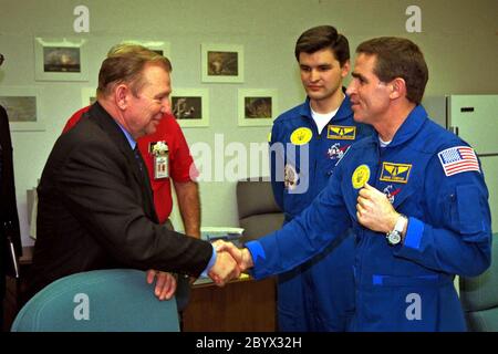 Der Präsident der Ukraine, Leonid Kutschma, schüttelt die Hände mit Nutzlast-Spezialist Leonid Kadenyuk, rechts, als Backup-Nutzlast-Spezialist Yaroslav Pustovyi, beide von der National Space Agency of Ukraine, schaut auf während der Vorlaufaktivitäten bis zum geplanten 19. November starten von STS-87. STS-87 wird der vierte Flug der US-amerikanischen Weltraumschadenträgerload und des einsatzfähigen Satelliten Spartan-201 sein. Während der Mission wird Kadenyuk die Brassica-Rapa-Pflanzen im Rahmen des Collaborative Ukrainian Experiment, kurz CUE, an Bord der Columbia-Mission bestäuben 16. Das CUE-Experiment ist Stockfoto