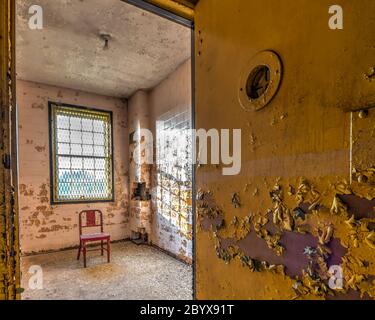 Roter Metallstuhl in der Isolationsabteilung eines verlassenen Krankenhauses Stockfoto