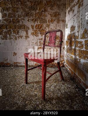 Roter Metallstuhl in der Isolationsabteilung eines verlassenen Krankenhauses Stockfoto