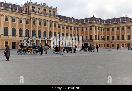 Pferdekutschen stehen vor dem Schloss Schönbrunn, einem Rokoko-Schloss mit 1441 Zimmern in Hietzing, Wien, Österreich. Stockfoto