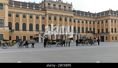 Pferdekutschen stehen vor dem Schloss Schönbrunn, einem Rokoko-Schloss mit 1441 Zimmern in Hietzing, Wien, Österreich. Stockfoto