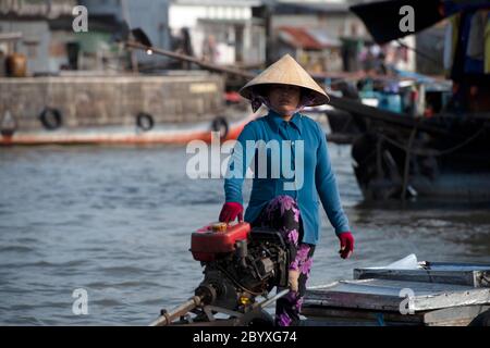 Eine Frau auf ihrem Boot auf dem schwimmenden Markt auf dem Hau-Fluss in Can Tho, Mekong Delta Region, Südvietnam. Stockfoto