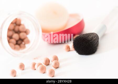 Zusammensetzung aus bronzing Perlen und Make-up Pinsel gewinkelt Stockfoto