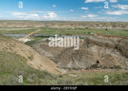 Blick auf Dorothy, Alberta, Kanada aus dem Südwesten im Frühling. Weiler im Vordergrund, Geisterstadt über Autobahn, Highway 848 Brücke auf der linken Seite. Stockfoto