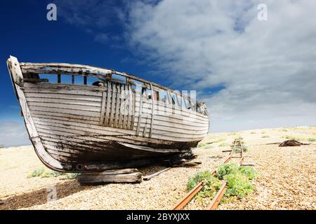 Holzfischerboot links zu verfaulen und Verfall auf dem Kiesstrand in Dungeness, England, Großbritannien. Stockfoto