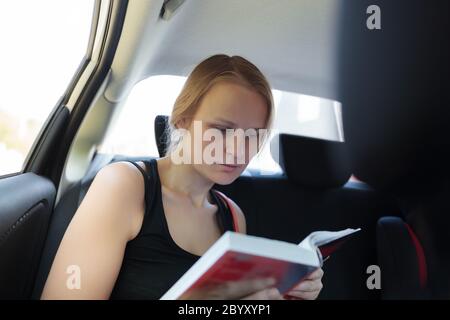 Frau liest ein Buch im Auto Stockfoto