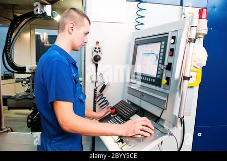 Arbeiter, der CNC-Maschinenzentrum betreibt Stockfoto