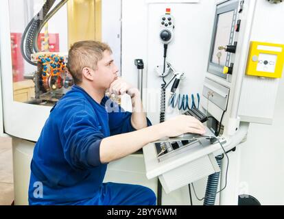 Arbeiter, der CNC-Maschinenzentrum betreibt Stockfoto