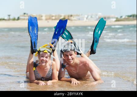 Aktives Paar am Strand mit Schnorchelset Stockfoto