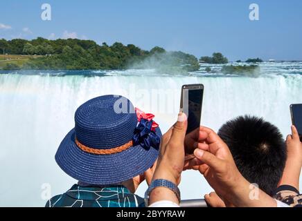 NIAGARA FALLS, Kanada - 25. JULI 2019: Leute, die selfie über Niagara Falls an einem schönen, sonnigen Tag. Kanadische anzeigen. Niagara Falls sind drei Stockfoto