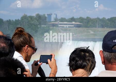 NIAGARA FALLS, Kanada - 25. JULI 2019: Leute, die selfie über Niagara Falls an einem schönen, sonnigen Tag. Kanadische anzeigen. Niagara Falls sind drei Stockfoto