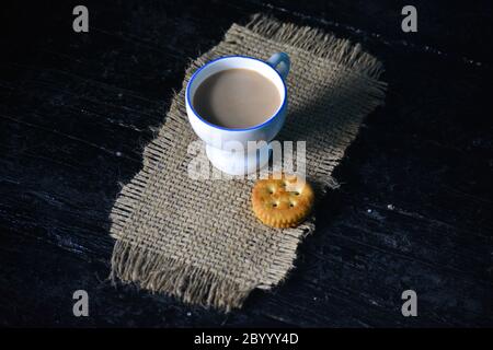 Eine Tasse Tee mit Keksen auf altem dunklen Holzhintergrund Stockfoto