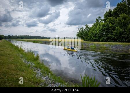 Zwei Kanufahrer sitzen im Kanu und paddeln auf einem Kanal Stockfoto