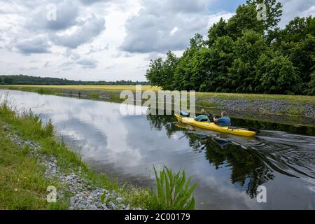 Zwei Kanufahrer sitzen im Kanu und paddeln auf einem Kanal Stockfoto