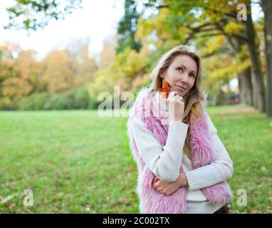 Die attraktive Frau spaziert im Herbstpark Stockfoto