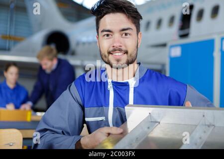 Mechaniker, der an einem kleinen Flugzeug in einem Hangar arbeitet Stockfoto