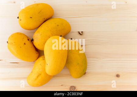 Gelbe Mangos aus nächster Nähe. Frische reife Bio-Früchte auf Holzhintergrund, flacher Lay, Kopierraum Stockfoto