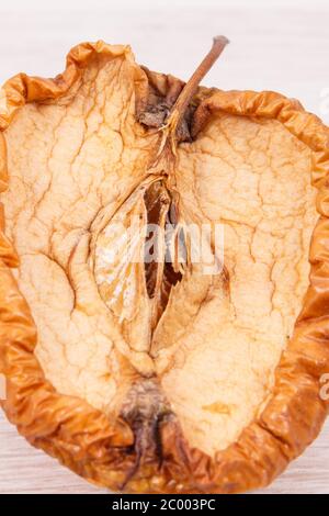 Alte faltige schimmelige Apple an Bord, ungesund und ekelhaftes Essen Stockfoto