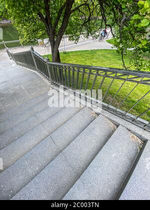 Steintreppe unten im Sommerpark. Steintreppe in der Nähe von blühendem Baum Stockfoto