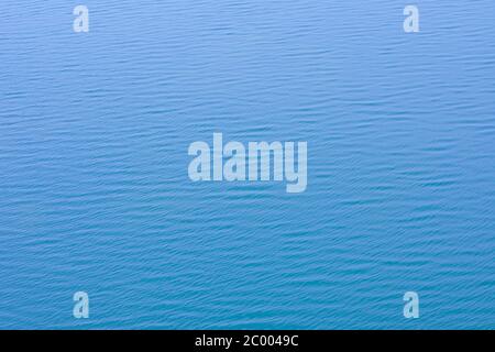 Foto von blauem Wasser Hintergrund mit Wellen. Noch blaue Meerwasseroberfläche als Hintergrund. Stockfoto