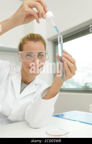 Junge Frau Techniker verwendet eine Pipette in einem chemischen Labor Stockfoto