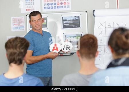 Stattliche senior Fahrlehrer in einer Klasse Stockfoto