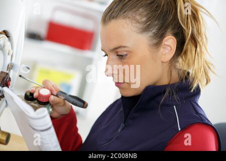 Weibliche auszubildende Klempner Arbeiten an zentralen Heizkessel Stockfoto