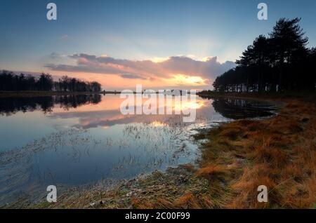 Herbstuntergang über wildem See Stockfoto