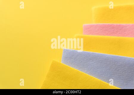 Bunte, trockene Tücher für die Reinigung verschiedener Oberflächen in Küche, Bad und Auto. Leere Stelle auf gelbem Hintergrund. Reinigungsdienstkonzept. Normal Stockfoto