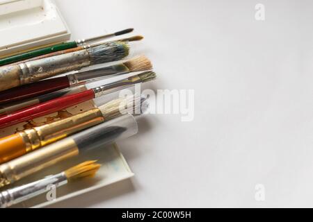 Verschiedene Pinsel zum Zeichnen mehrfarbiger Farben weißer Hintergrund. Flaches Layout mit Platzwerbung Design Text. Stockfoto