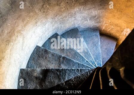 Alte schmale Wendeltreppe aus Stein im mittelalterlichen Turm. Stockfoto