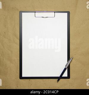 Ein Tablett mit einem weißen Blatt im A4-Format mit Stift auf einem beigen Bastelpapier. Konzept der Analyse, des Studiums, der aufmerksamen Arbeit. Stock Foto mit leerem Platz für Ihren Text und Design. Stockfoto