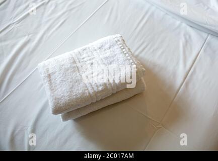 Stapel von weißen Handtücher auf dem Bett Stockfoto