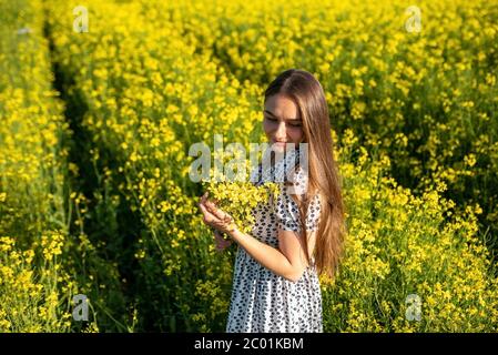 Mädchen in einem Rapsfeld in der Sonne. Stockfoto