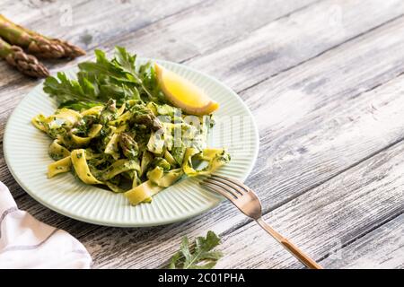 Tagliatelle mit Spinat und Spargel. Pasta mit Sahne-Sauce und Gemüse Stockfoto