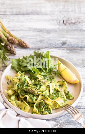 Tagliatelle mit Spinat und Spargel. Pasta mit Sahne-Sauce und Gemüse Stockfoto