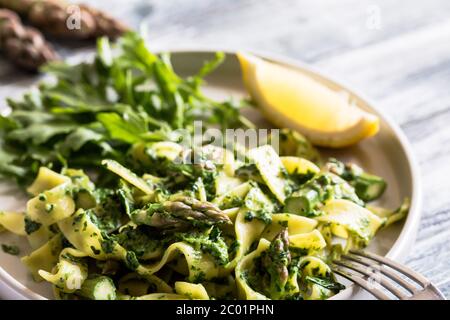 Tagliatelle mit Spinat und Spargel. Pasta mit Sahne-Sauce und Gemüse Stockfoto