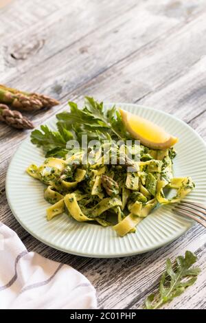 Tagliatelle mit Spinat und Spargel. Pasta mit Sahne-Sauce und Gemüse Stockfoto