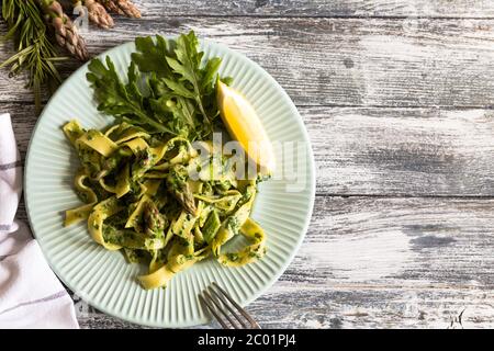 Tagliatelle mit Spinat und Spargel. Pasta mit Sahne-Sauce und Gemüse Stockfoto